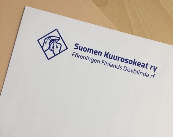 valkoinen kirjekuori, jossa on Suomen Kuurosokeat ry:n sininen logo