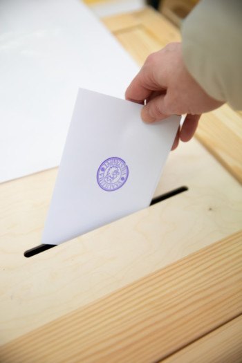 Äänestyslipuke pudotetaan vaaliuurnaan.