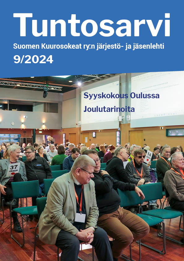 Tuntosarvi 9/2024 kansikuva. Kuvassa syyskokousväkeä ja tulkkeja kokoustilassa tuoleilla